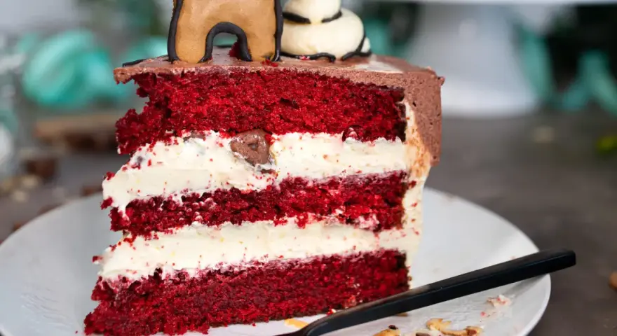 Ein Stück saftiger Red Velvet Cake mit cremiger Füllung, perfekt für das red velvet cake rezept original.