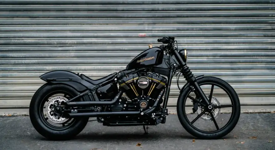 Czarny, klasyczny motocykl Harley-Davidson z błyszczącym lakierem i złotymi akcentami na silniku, gotowy na drogę.