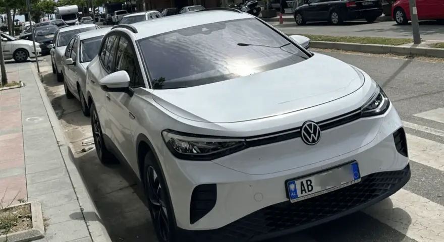 Weißer VW ID.4 mit albanischem Kennzeichen, bereit für seine nächste Fahrt als Taxi in Albanien.