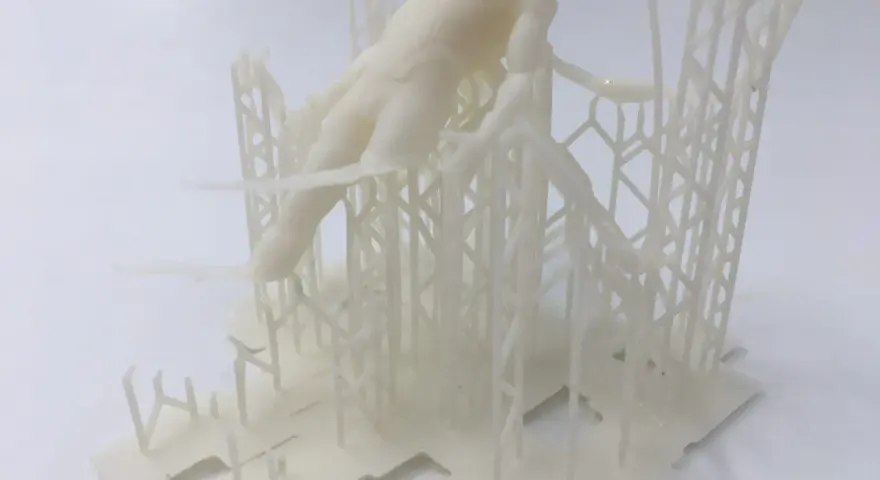 Model ludzkiej postaci otoczony kratownicą, ilustrujący, jak działa drukarka 3D, tworząc skomplikowane struktury warstwa po warstwie.