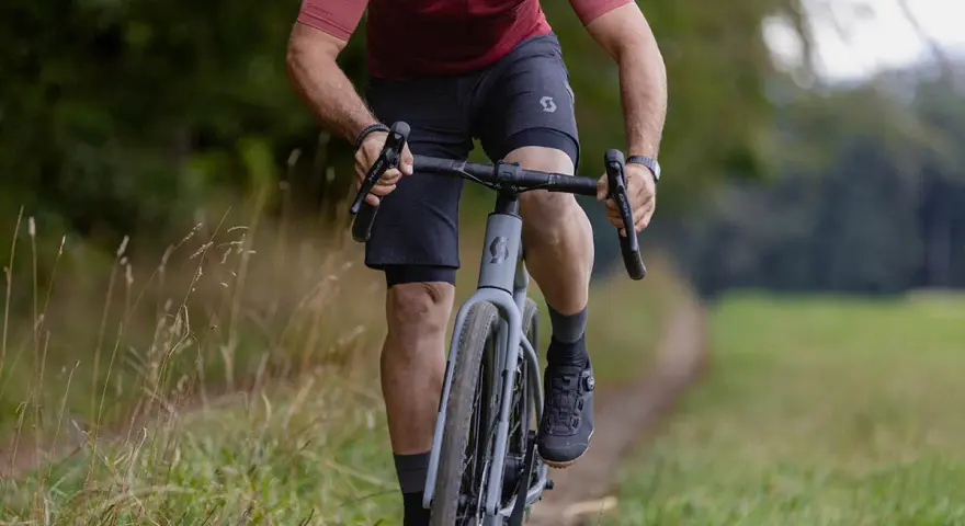 A cyclist rides on a gravel path, showing how many calories 10 minutes of cycling burns.
