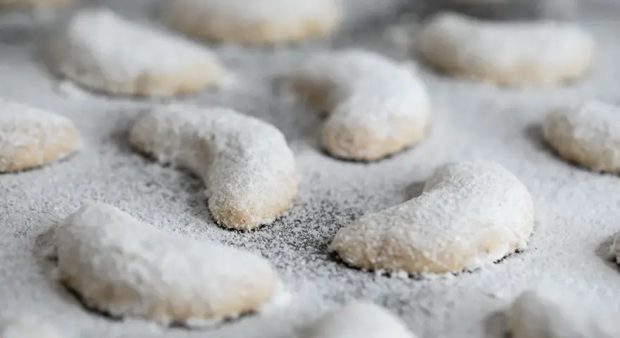 Zarte Vanillekipferl, mit Puderzucker bestäubt, warten darauf, genossen zu werden.