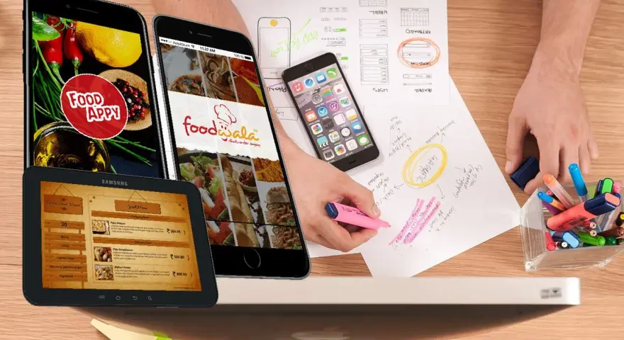 Diseño de apps para restaurantes: teléfonos y tabletas muestran menús y logos. Bocetos y marcadores sugieren planificación.