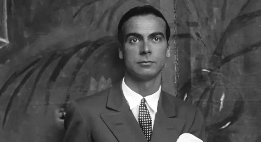 Ritratto di Cristóbal Balenciaga, il cui nome è sinonimo di alta moda. Indossa un abito elegante con cravatta a pois.