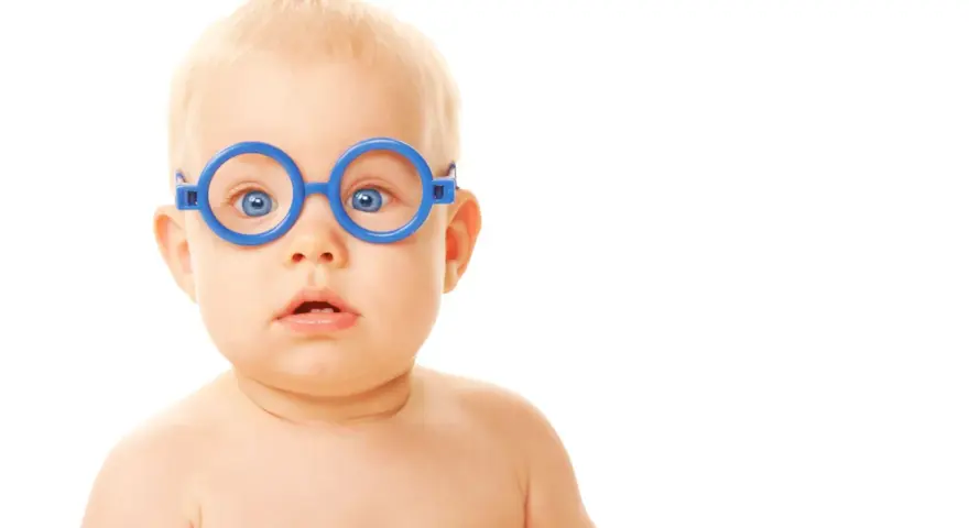 Niebieskie okulary na nosie niemowlaka, który ma lekki zez.