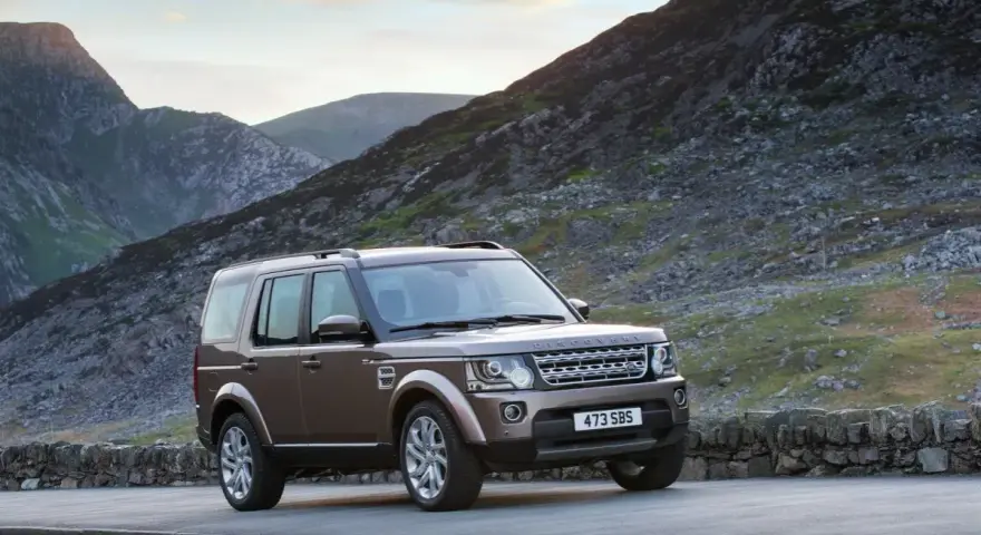 Brązowy Land Rover Discovery 4 na tle górskich krajobrazów. Nawet w tak malowniczym miejscu mogą pojawić się land rover discovery 4 awarie i problemy.