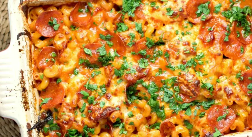 Zapiekanka makaronowa z serem, pepperoni i natką pietruszki w naczyniu żaroodpornym.