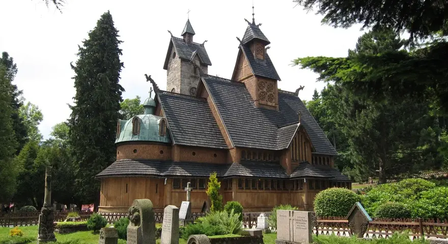 Drewniana świątynia Wang w Karpaczu, otoczona cmentarzem i drzewami. Ciekawostki o jej budowie i historii przyciągają turystów.