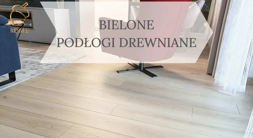 Jasne, bielone podłogi drewniane w nowoczesnym salonie. Wygodny fotel i dywan dopełniają aranżację.