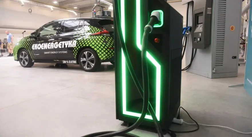 Elektryczny samochód "Ekoenergetyka" przy nowoczesnej ładowarce. Od września 2026 r. każdy blok musi mieć punkt ładowania aut elektrycznych.