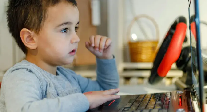 Chłopiec z zaciekawieniem ogląda na laptopie materiały o biologii dla dzieci.