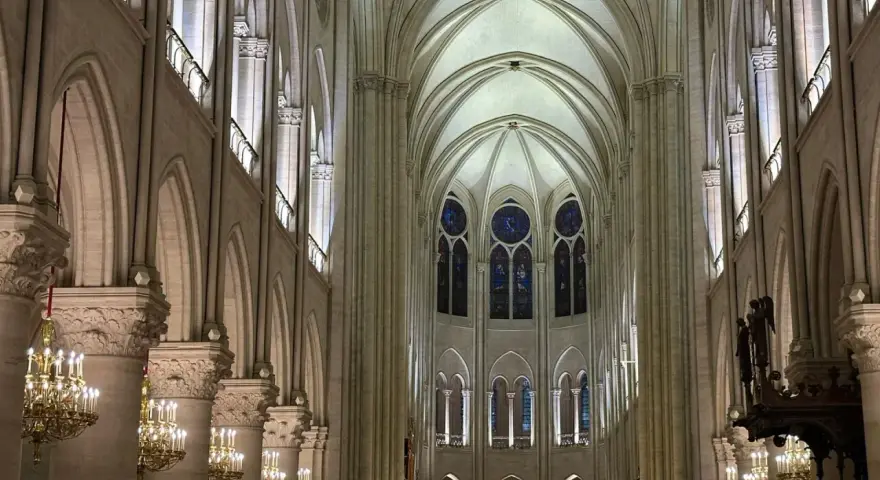 Interior de Notre Dame, con sus impresionantes arcos góticos, vitrales y candelabros dorados. Las **entradas Notre Dame** se abren a este majestuoso espacio.