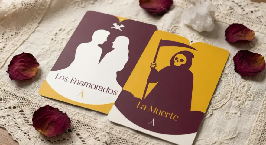 Dos cartas de tarot, "Los Enamorados" y "La Muerte", yacen sobre tela de encaje, rodeadas de pétalos de rosa secos y un cristal.
