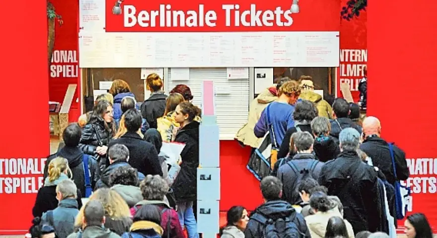 Menschen stehen Schlange am **Berlinale Publikumstag** vor dem Ticketschalter.