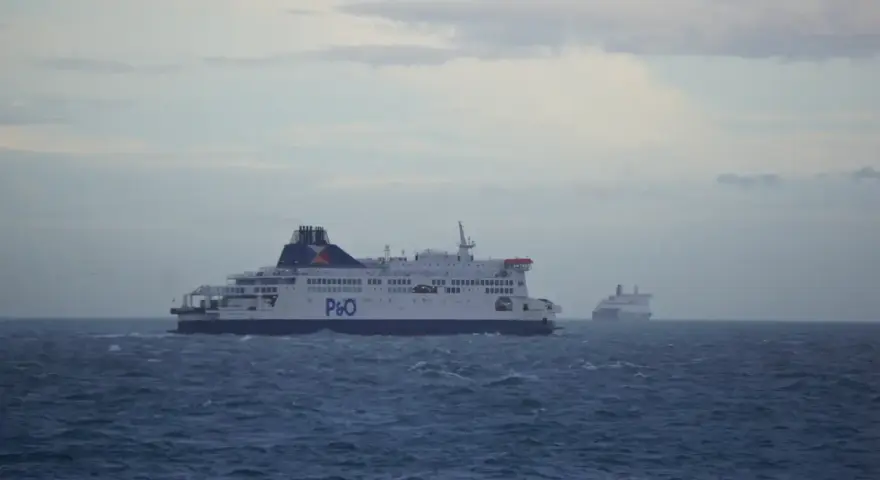 Dwa promy P&O płyną po wzburzonym morzu. Jeden z nich, bliżej, jest większy i wyraźniejszy. To widok z promu podczas przejazdu pod Kanałem La Manche.