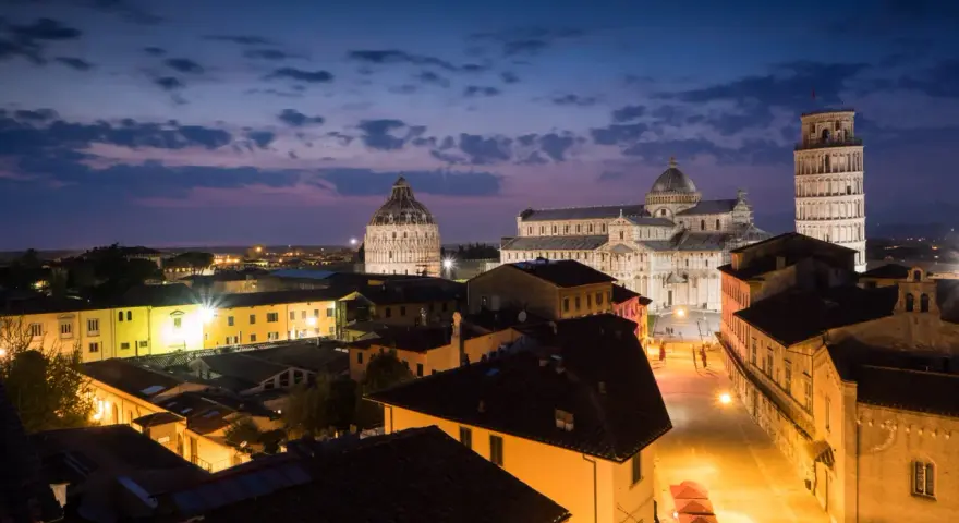 Magnifique paysage de Pise au crépuscule, avec la cathédrale, le baptistère et la tour penchée illuminés. Une belle photographie de paysage.