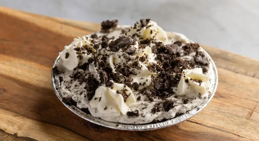 Pyszna masa oreo do tortu, udekorowana bitą śmietaną i pokruszonymi ciasteczkami. Idealna na deser!