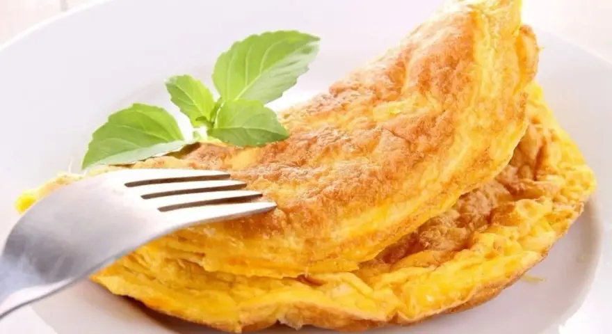 Puszysty omlet z piekarnika, złocisty i lekki, z gałązką bazylii. Idealny na śniadanie.