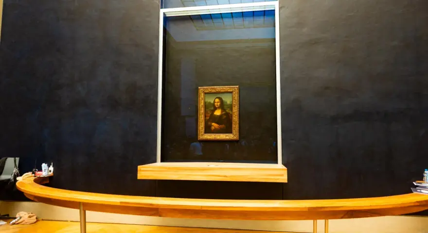 Mona Lisa w muzeum, za pancerną szybą. Słynny obraz Leonarda da Vinci przyciąga tłumy zwiedzających.