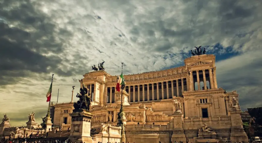 Monument imposant à Rome, sous un ciel orageux. Pensez à la fiscalité pour votre projet d'expatrier en Italie.