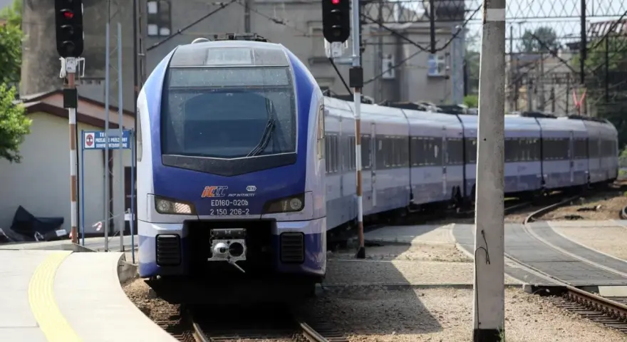 Niebiesko-biały pociąg PKP Intercity ED160-020b stoi na stacji.