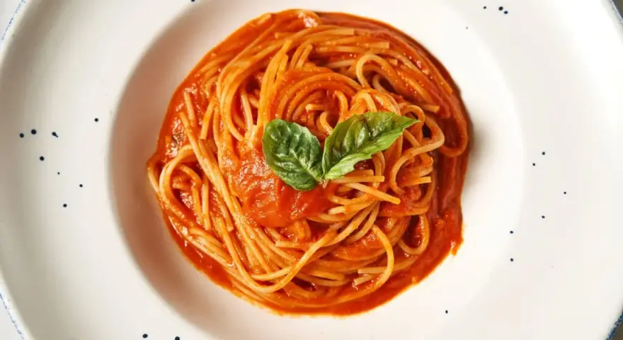 Pyszne spaghetti z sosem pomidorowym i bazylią. Prawdziwa **Italia na talerzu**, która rozpływa się w ustach.