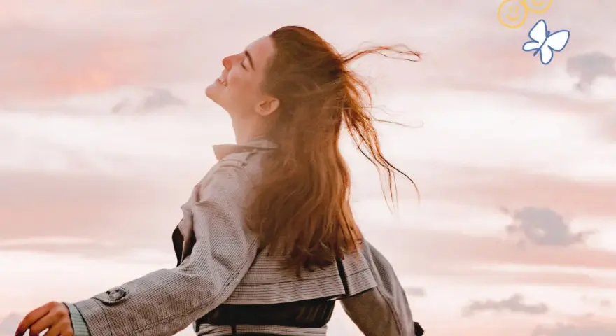 Embracing the sky, a woman with flowing red hair embodies joy, a feeling achievable through 7 daily habits. A butterfly and smiley faces float above.