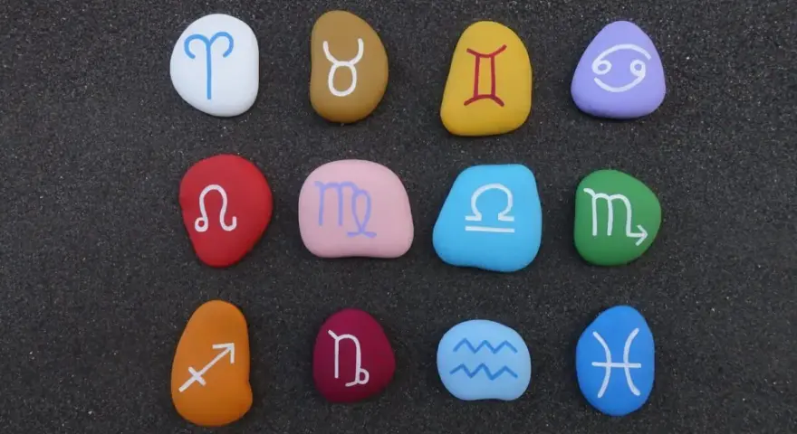 Kolorowe kamienie z symbolami zodiaku, ułożone w rzędach. Idealne do sprawdzania dopasowania znaków zodiaku.