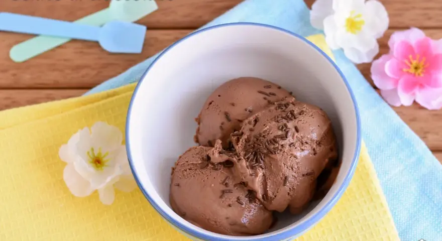 Coppetta di gelato al cioccolato, perfetto risultato di una ricetta gelato con gelatiera. Spolverata di granella per un tocco goloso.
