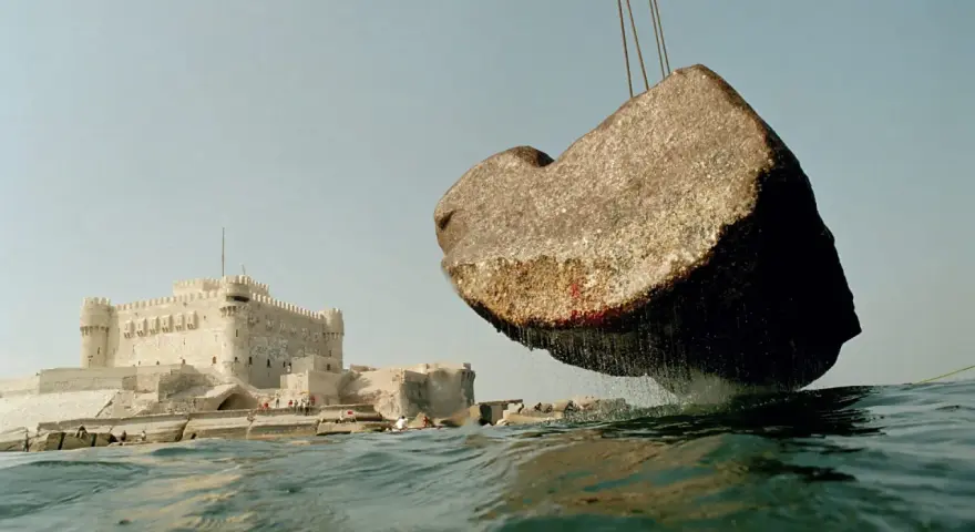 Un bloc de pierre, vestige du phare d'Alexandrie, est soulevé au-dessus des eaux, près de la citadelle de Qaitbay.