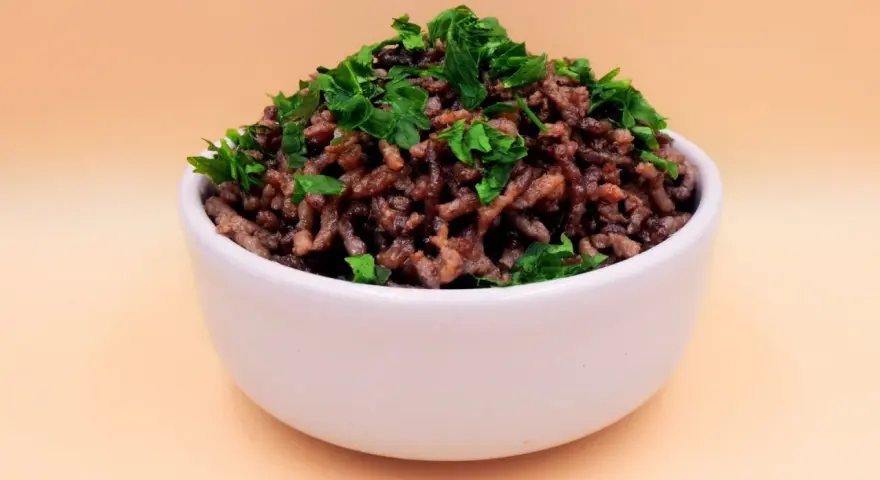 Mielona wołowina z natką pietruszki w białej miseczce. Idealna baza do wielu dań, np. do sosu bolognese. Prosty przepis na wołowinę.