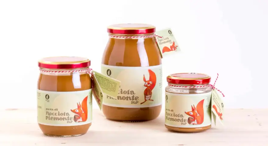 Tre barattoli di pasta di nocciola Piemonte IGP, con etichette raffiguranti uno scoiattolo.