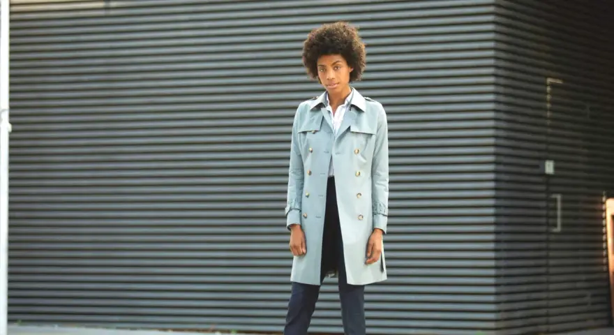 Mujer con un trench ligero y elegante, lista para enfrentar el día con estilo.