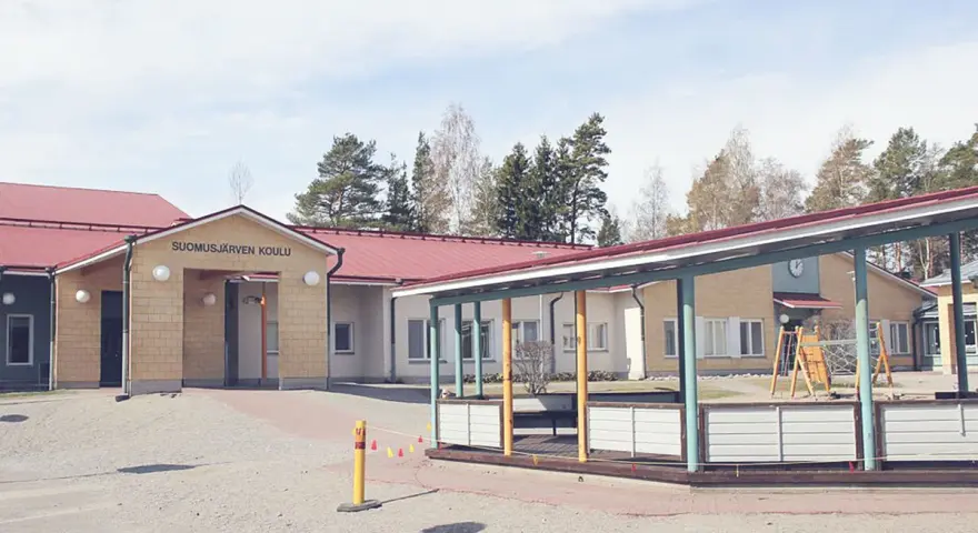 Suomusjärven Koulu, czyli szkoła w Finlandii, z placem zabaw i zielonymi terenami. Ciekawostki o fińskim systemie edukacji często podkreślają jego innowacyjność.