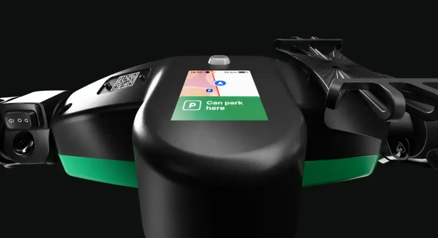 Lenkrad eines E-Scooters mit Display, das die Bolt Taxi App anzeigt. "Can park here" ist auf dem Bildschirm zu lesen.