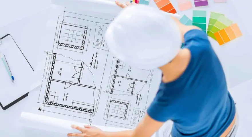 Pracownia znanych projektantów wnętrz: szkice planów, palety kolorów i biały kask.