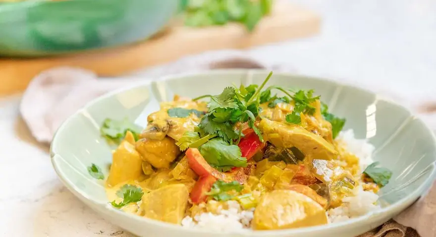 En krämig kyckling curry med ris, toppad med färsk koriander. En härlig och smakrik rätt.