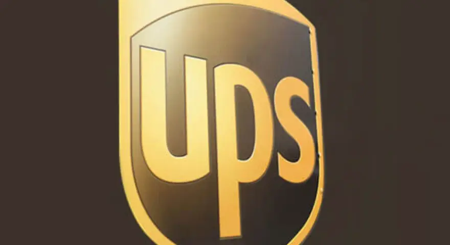 Logo UPS dorato su sfondo scuro. Informazioni sullo stipendio corriere UPS.