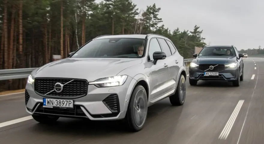 Dwa Volvo XC60 T8 jadące po drodze leśnej. Jeden srebrny, drugi ciemnoszary.