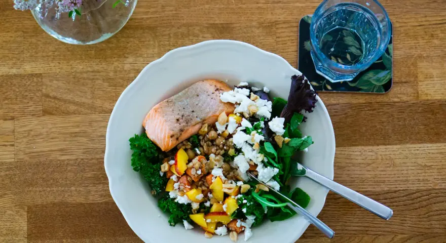Laxskål med krispig grönkål, frukt, nötter och ost. En hälsosam måltid med 30g protein.