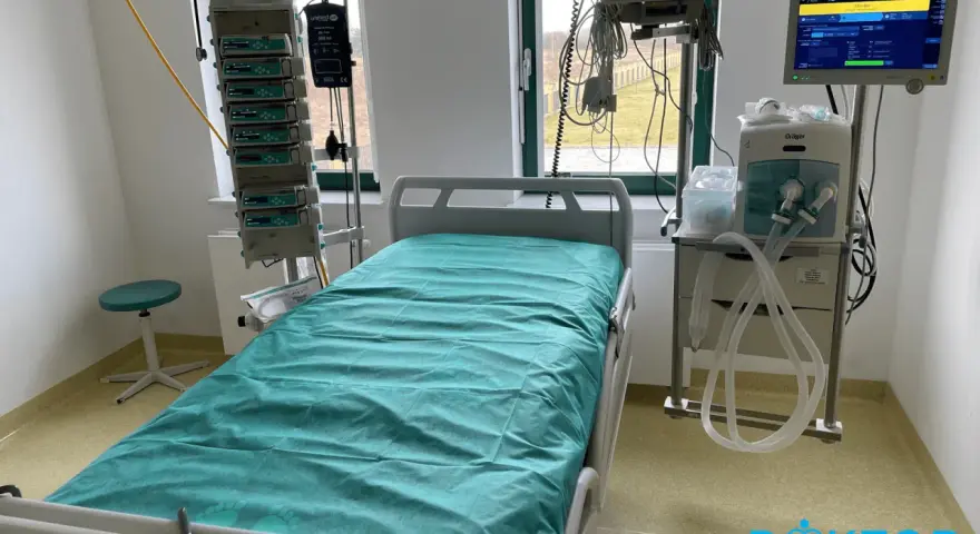 Łóżko szpitalne na oddziale intensywnej terapii z aparaturą medyczną.