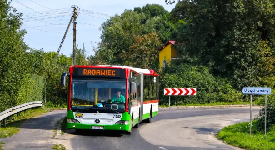 Autobus linii 43 jedzie do Radawca. Na drodze znak "Urząd Gminy".