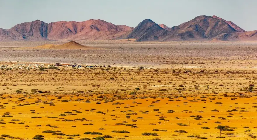 Pustynny krajobraz Namibii z górami w tle. Idealny czas na podróż do Namibii to okres od maja do października, kiedy jest sucho i chłodniej.
