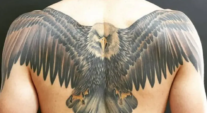 Imponujący tatuaż orła na plecach, z rozpostartymi skrzydłami, symbolizujący wolność i siłę.
