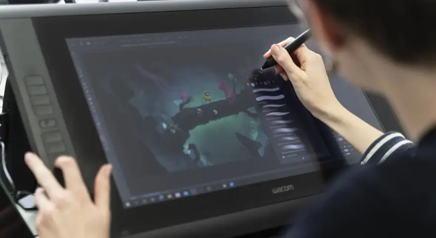 Person im Animation Studium nutzt Grafiktablett für digitale Kunst.