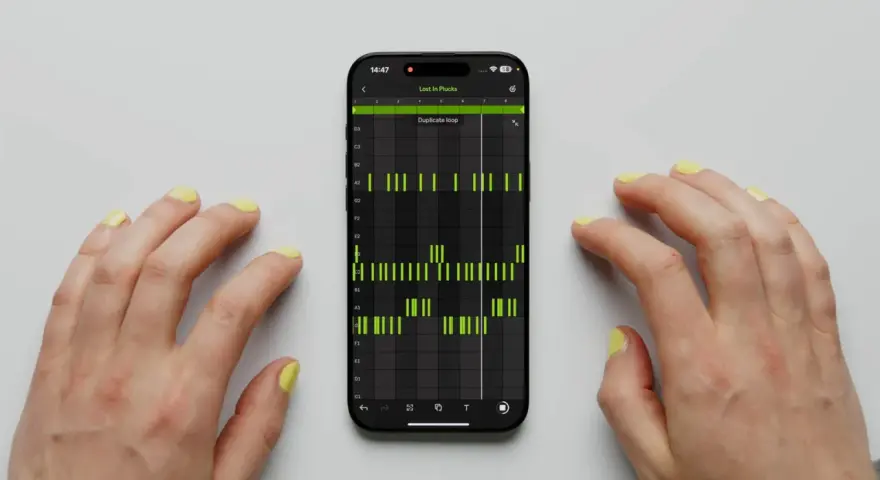 Hände tippen auf einem Smartphone, das die Ableton Note App mit einer Musiksequenz zeigt.
