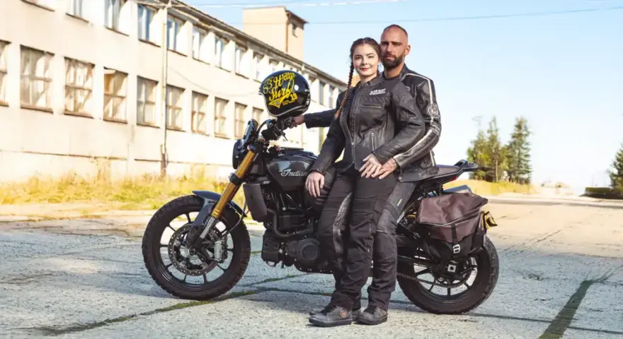 Para motocyklistów w skórzanych kurtkach siedząca na motocyklu Indian, z kaskiem.