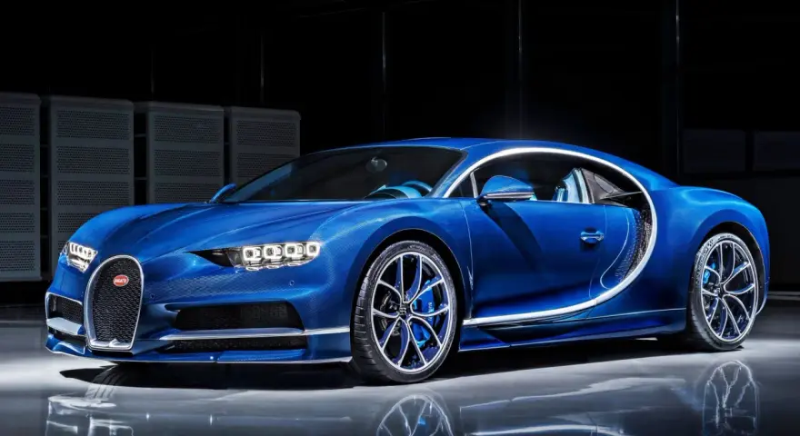 Niebieski Bugatti Chiron błyszczy w studio, jego aerodynamiczna linia podkreślona białym akcentem.