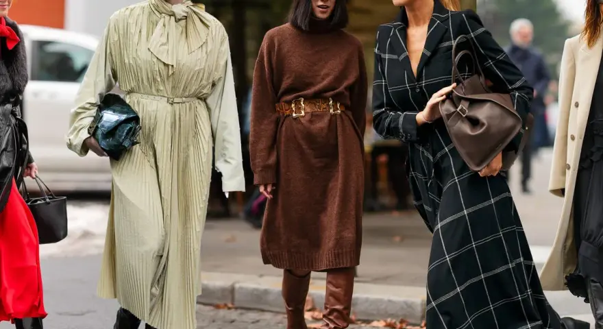 Estilos de moda callejera: vestidos largos, botines y bolsos. Se ve que **que largo de vestido se lleva** esta temporada.