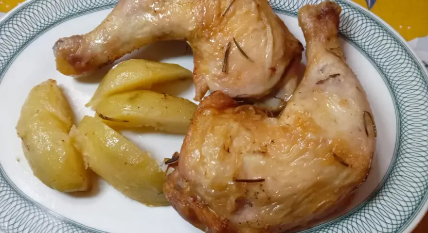 Cosce di pollo in friggitrice ad aria, dorate e succulente, servite con patate arrosto.